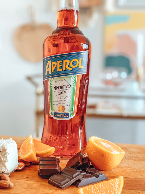 sliced oranges and a bottle of aperol on a cutting board